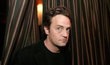 Matthew Perry în timp ce ține ce citește în fața publicului dintr-o carte