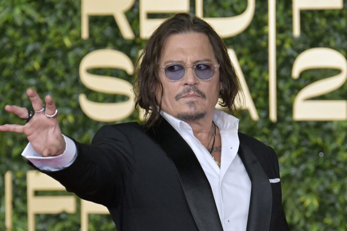 Johnny Depp, într-un costum negru, cu cămașă albă