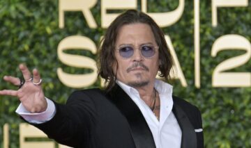 Johnny Depp, într-un costum negru, cu cămașă albă