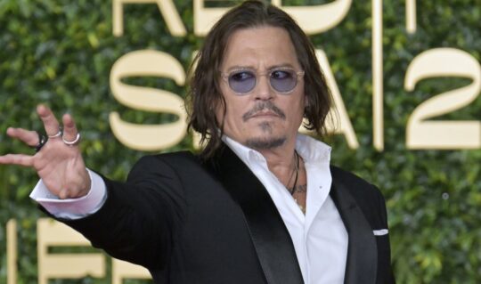 Johnny Depp, într-un costum negru, cu cămașă albă