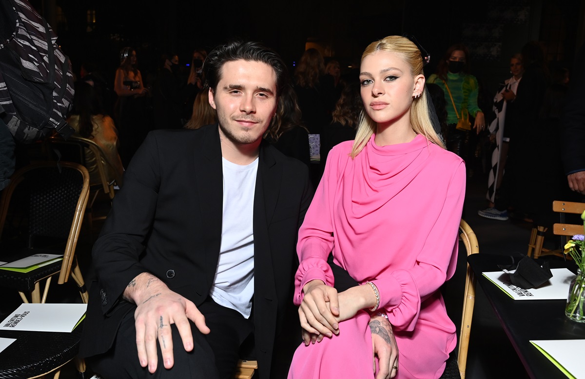 Brooklyn Beckham și Nicola Peltz în timp ce stau pe scaune și pozează împreună